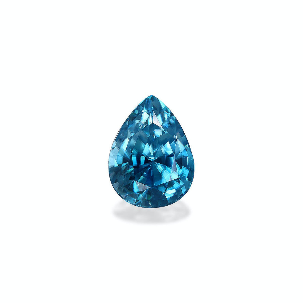 Le Zircon Bleu Bonnot Paris, une pierre précieuse taille brillant en forme de poire de 7,75 carats aux facettes acérées, reflète la lumière dans différentes nuances de bleu sur un fond uni et clair.