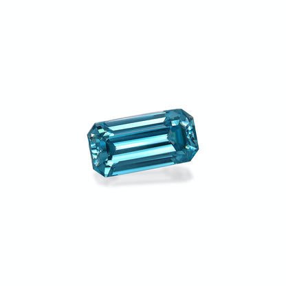 La pierre précieuse Zircon Bleu · 4,75 ct de Bonnot Paris est une pierre bleu profond taille émeraude sertie sur un fond blanc, présentant des facettes réfléchissantes qui mettent en valeur sa clarté et sa brillance.