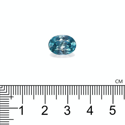 La pierre précieuse aigue-marine taille ovale Bonnot Paris Zircon Bleu de 6,12 carats est présentée à côté d'une règle avec des graduations en centimètres pour afficher sa taille.